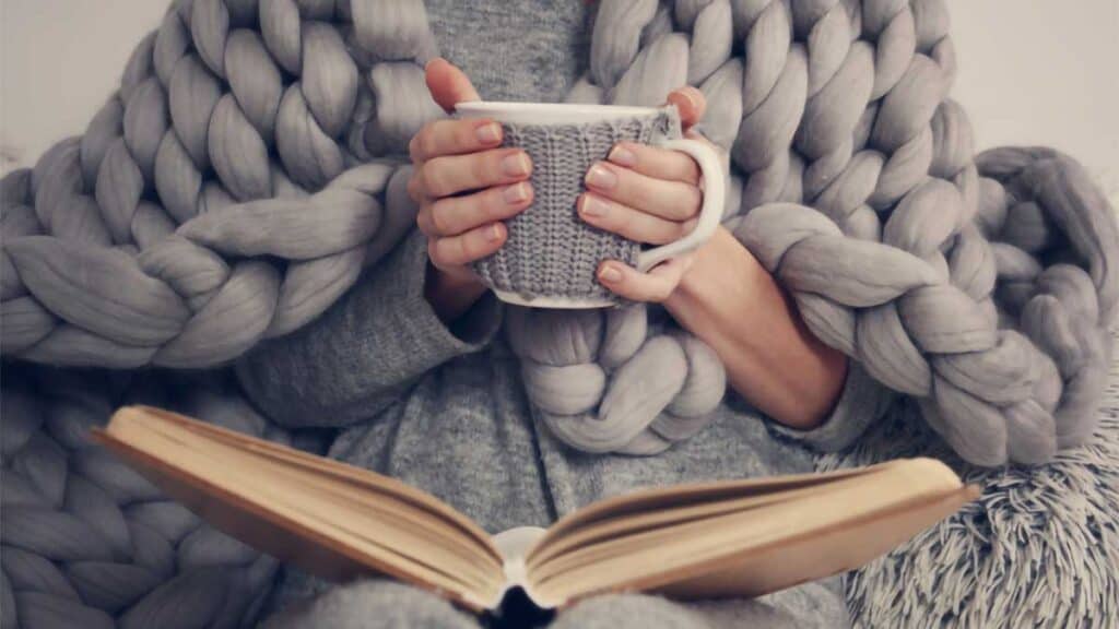 Bundled up in sweater reading book